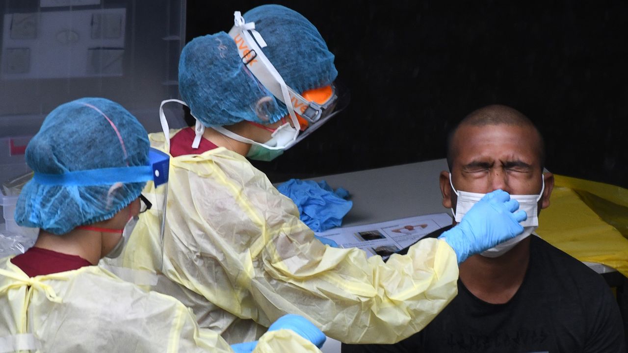 Health workers take a nasal swab in Singapore