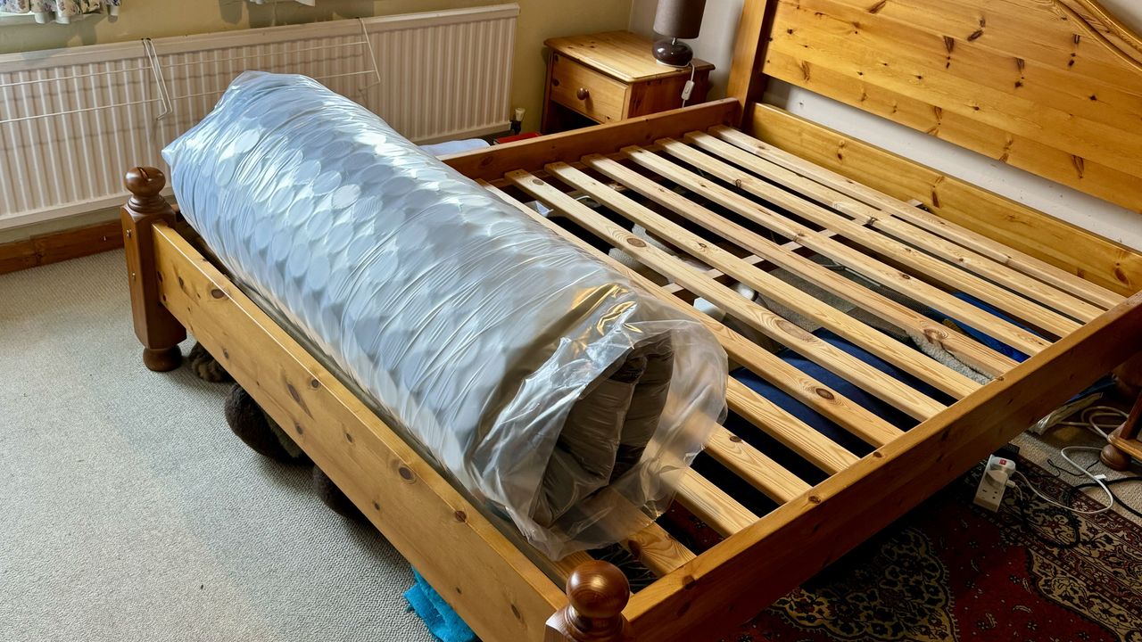 The image shows the DreamCloud Hyrbid Mattress vacuum packed and rolled