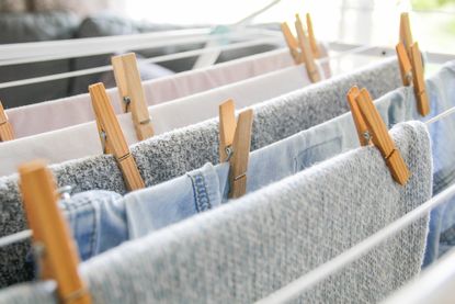 Clothes hung with wooden pegs on a drying rack