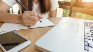 Student studying with laptop and phone