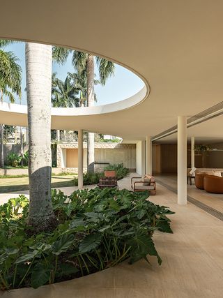 casa das palmeiras with its minimalist, low, white forms, curved openings and indoor/outdoor relationships in sao paulo's warm climate lifestyle