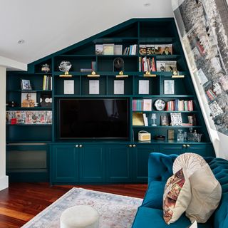 living room with blue bespoke shelving unit with books and a tv