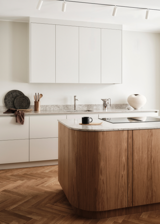 stylish modern kitchen with white cabinetry, a wooden island and an integrated electric hob