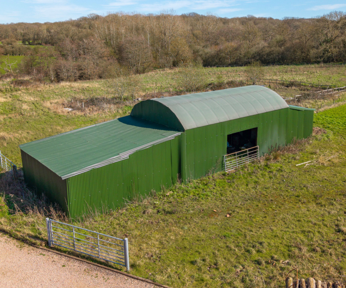 Green Dutch-style barn in field