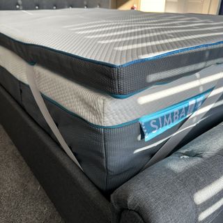 A close up of the Simba Hybrid Mattress topper showing its elastic corner straps