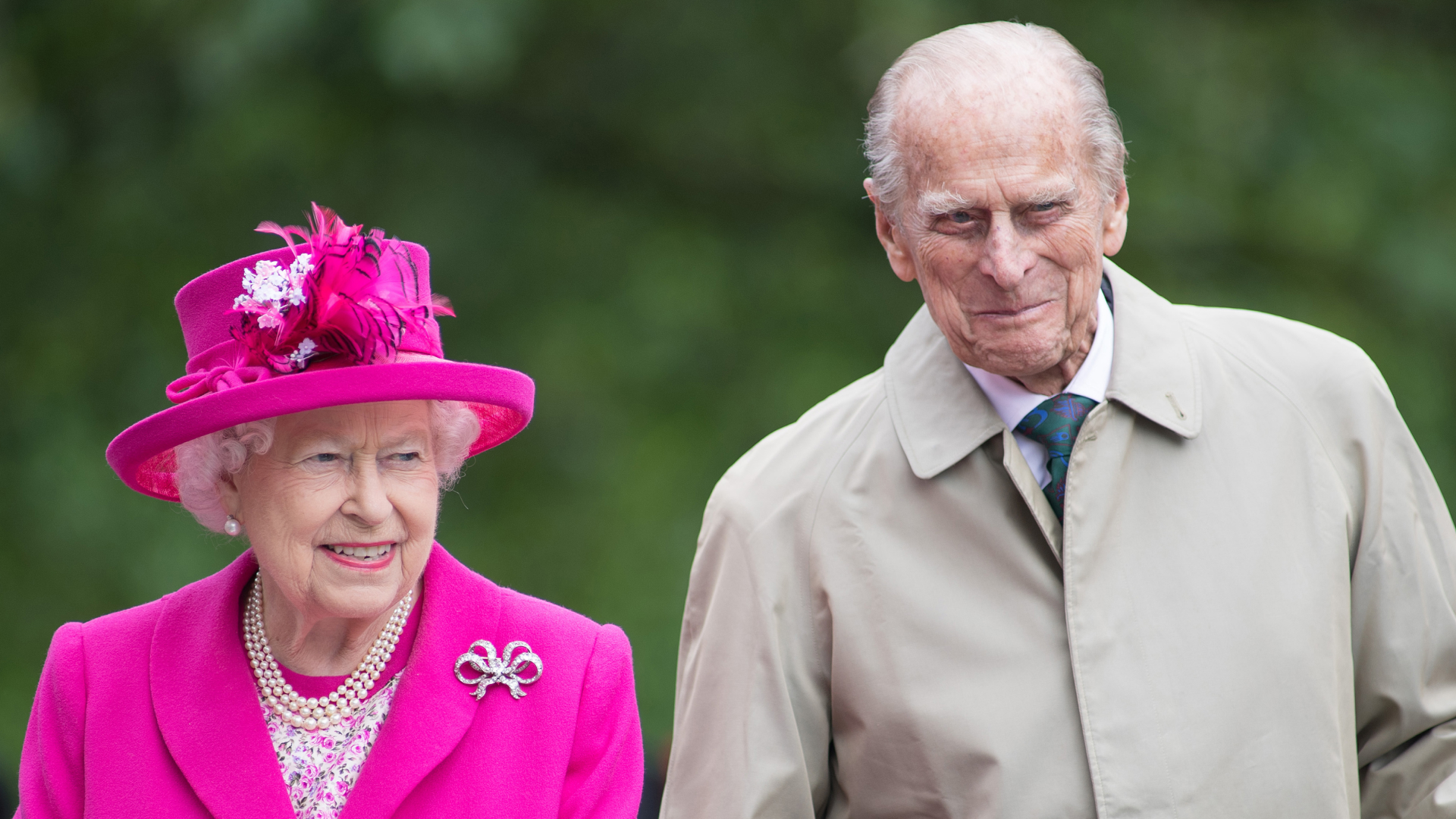 Queen Elizabeth II wears a bright pink suit with matching hat and Prince Philip smirks during The Patron's Lunch celebrations for The Queen's 90th birthday at The Mall on June 12, 2016