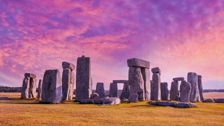 Summer Solstice 2022: Stonehenge under dramatic sunset sky with long shadows - stock photo