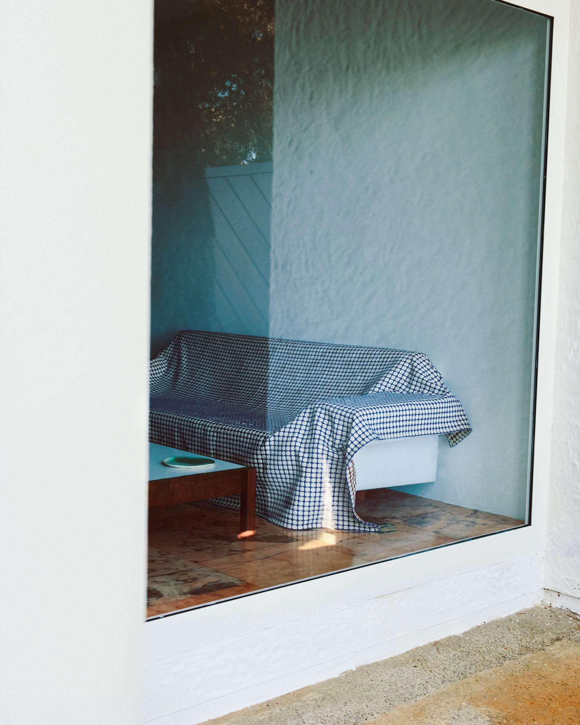sofa with throw behind white-framed window