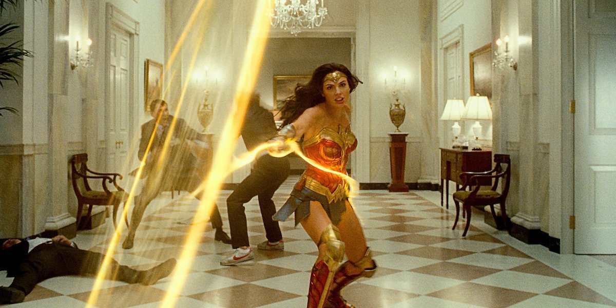 Wonder Woman (Gal Gadot) swings her lasso as men fight in the background in &#039;Wonder Woman 1984&#039;