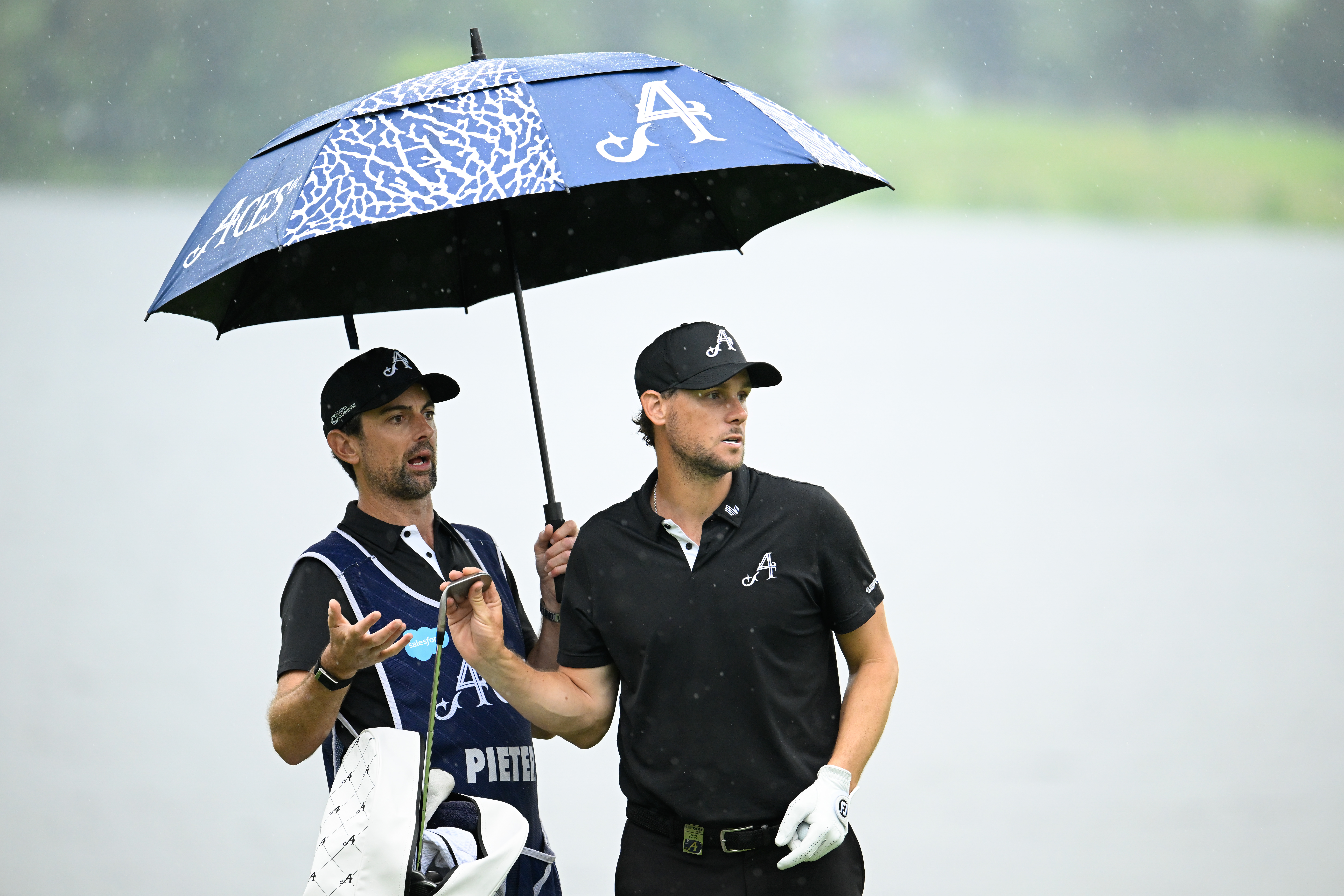 Thomas Pieters holds an umbrella