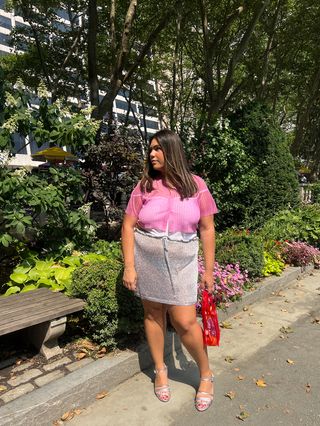 Ana Escalante wearing a pink cardigan, silver miniskirt, and silver heels with a red mesh bag from the J.Crew x Maryam Nassir Zadeh collaboration.