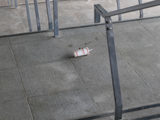 Discarded five guys drinks container on a set of stone steps