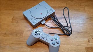A photo of the PlayStation Classic and its controller on a wooden table
