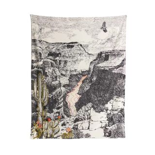 A black and white wall tapestry with a mountain scene
