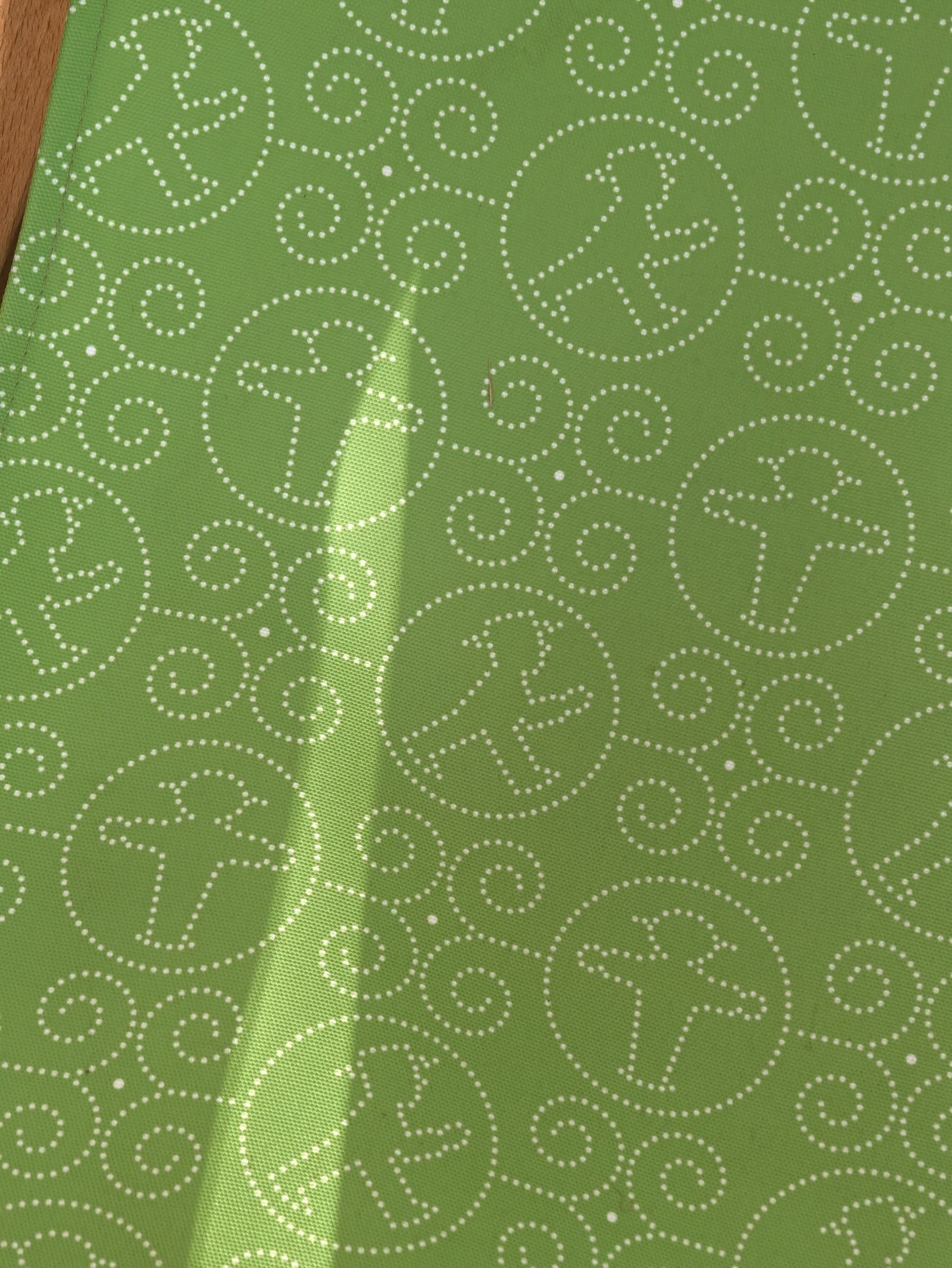 Close-up of green fabric patterned with white Ampelm&auml;nnchen pedestrian figures.
