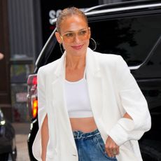 Jennifer Lopez wearing a white blazer, crop top, and jeans in NYC
