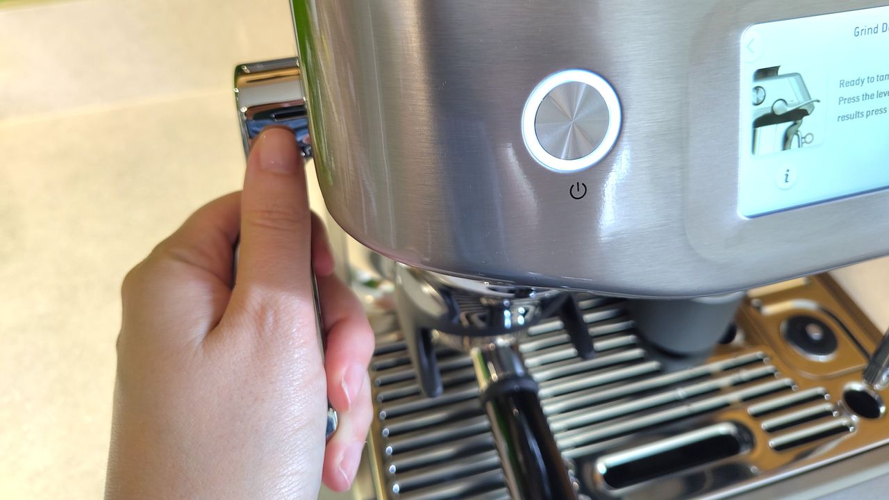 Person using tamping lever on Sage Barista Touch Impress coffee maker