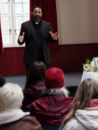 Village vicar Charles addresses the villagers during a vigil