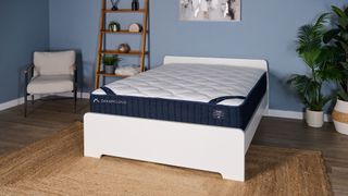 The DreamCloud Classic Mattress on a white bed frame in a modern light blue bedroom.