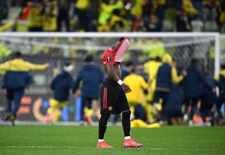 Fred covers his face as Villarreal celebrate Europa League victory in the background