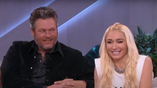Blake Shelton and Gwen Stefani laughing together on a couch while appearing on The Kelly Clarkson Show.