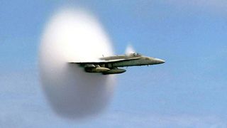 An F/A-18 Hornet aircraft speeds up to supersonic speed.