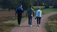 Golfers chatting walking off the tee