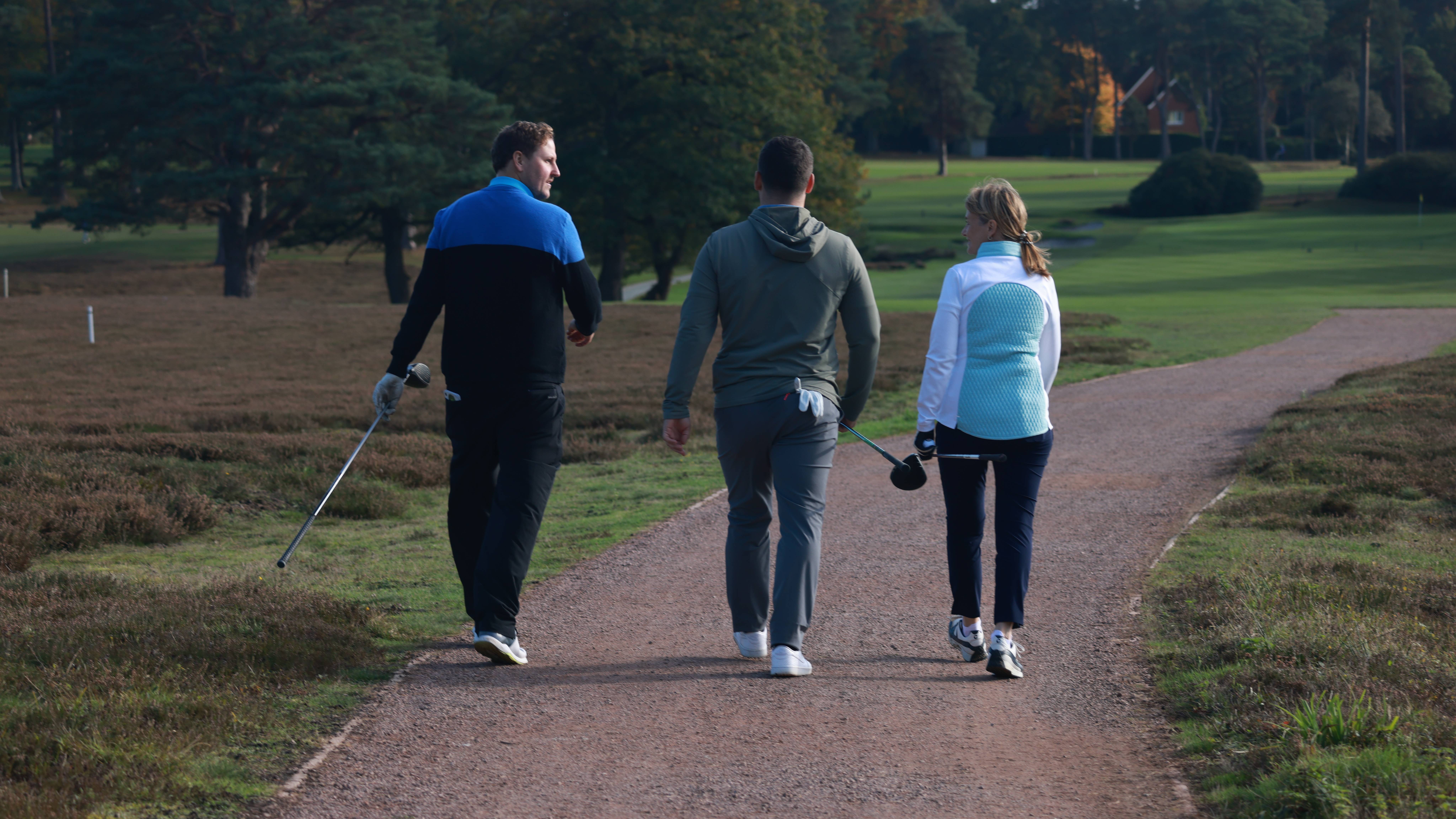 Golfers chatting walking off the tee