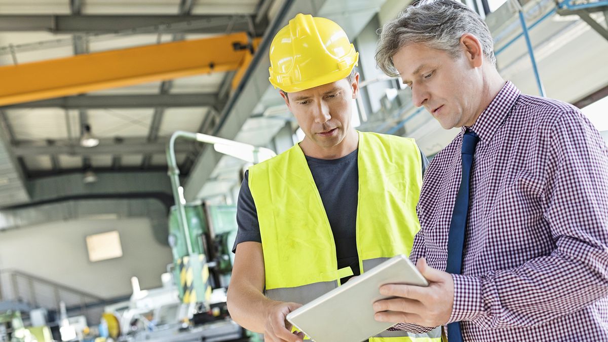 men looking at an ipad in a factory