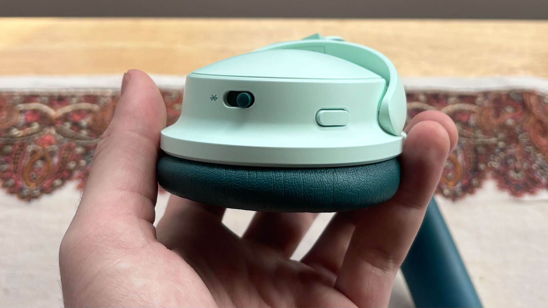 Bose QuietComfort Headphones (2nd Gen) over-ear headphones one arcup held in hand showing buttons