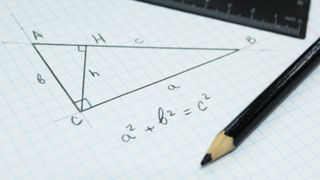 A notebook with pythagorean theorem calculations and a pencil and ruler