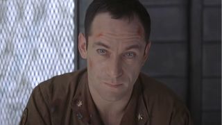 Jason Isaacs sits with scrapes and a look of concern in Event Horizon.