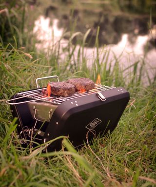 cooking burgers on a portable BBQ