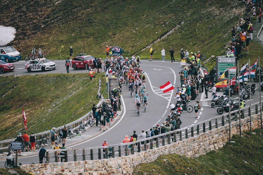 Spectators watch as the pack of cyclists ride past in a mountain area during the 4th stage from St. Johann Alpendorf to Kals am GroÃŸglockner (151,7 km) of the 2024 Tour of Austria on July 6, 2024. (Photo by Johann GRODER / various sources / AFP) / Austria OUT