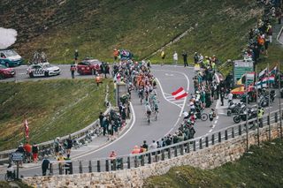 Os espectadores assistem a um grupo de cavaleiros passar por uma área montanhosa durante a quarta etapa de St. Johann Alpendorf a Kals am Grossglockner (151,7 km) do Tour da Áustria de 2024 em 6 de julho de 2024. (Foto: Johan Gruder / Várias Fontes / AFP ) / Áustria Fora