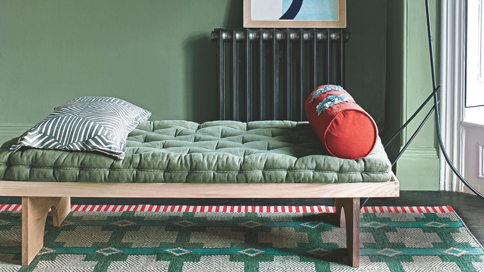 Green padded futon on low wooden frame