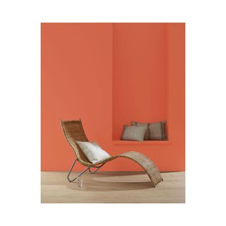 orange wall with rattan lounge seat