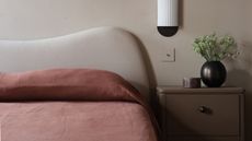a wavy headboard with red linen sheets on the bed