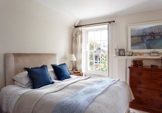 bedroom with blue bedlinen and dressed window