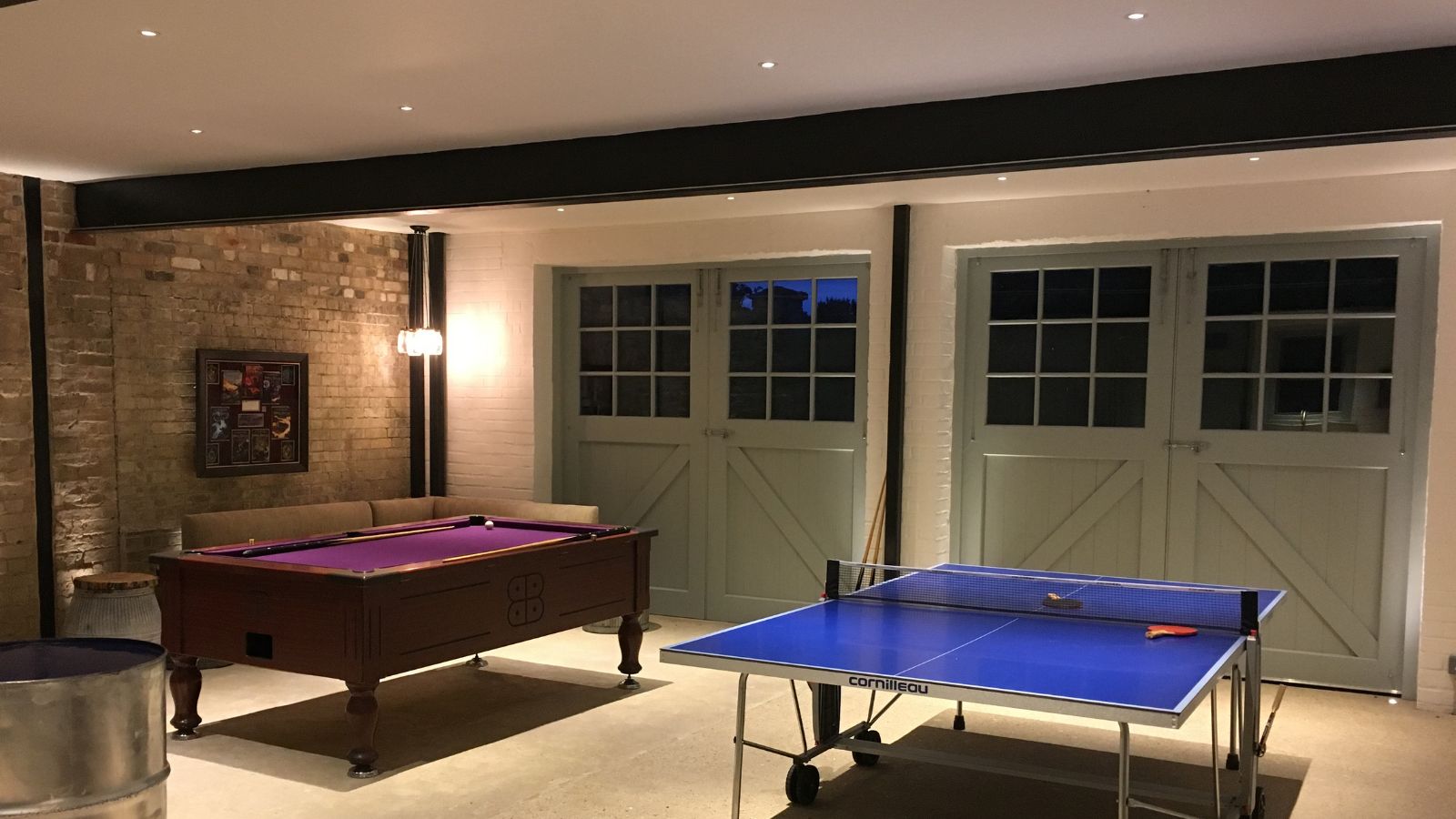 A converted garage with layered lighting and a games room inside