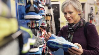 woman looking at running shoe in sports store