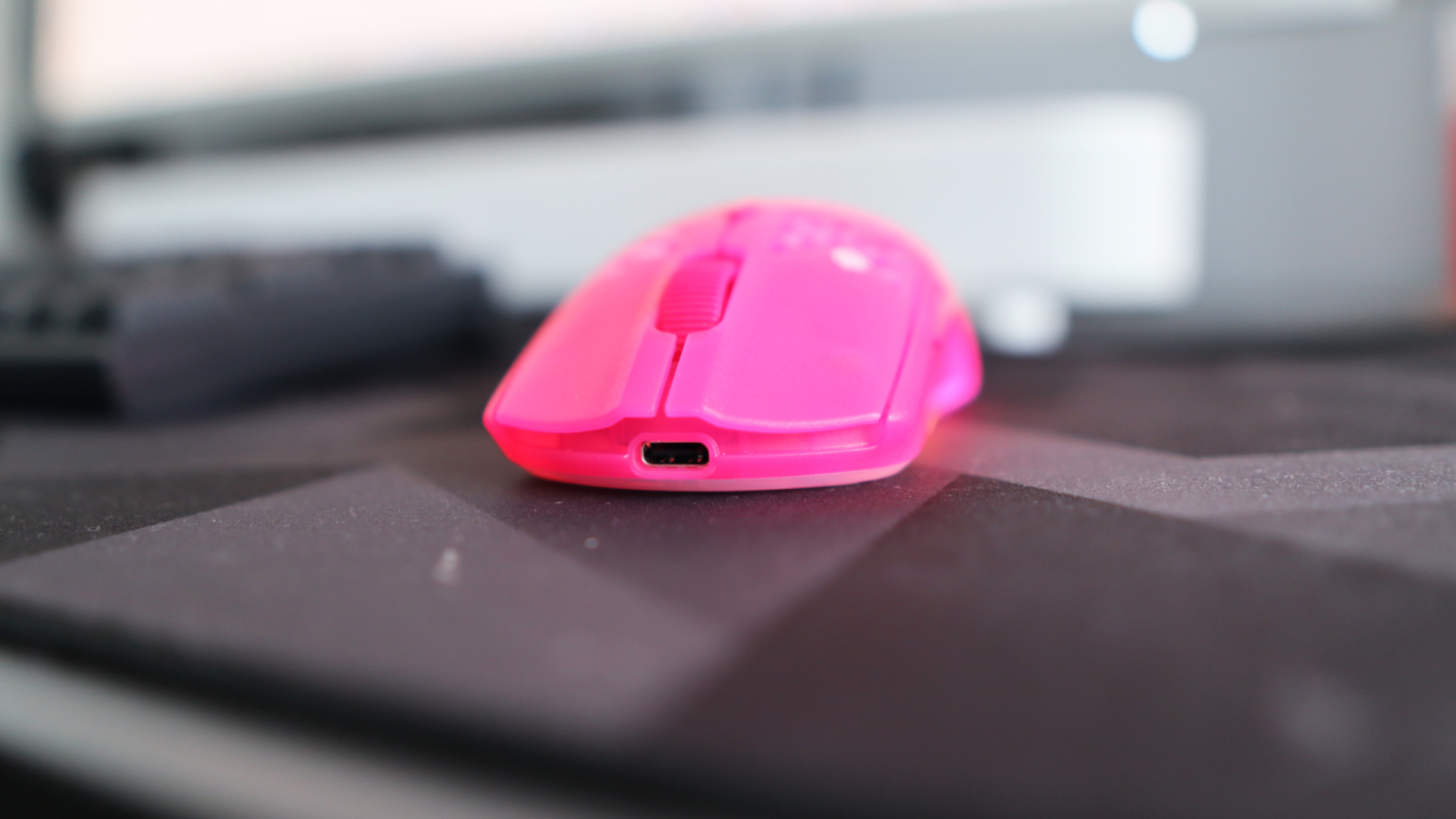 The SteelSeries Aerox 3 Wireless Gen 2 looking excellent in pink on a grey mousepad.