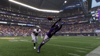 Madden 25 screenshot taken in photo mode - Vikings player stretches out to catch ball trailed by Raider defender