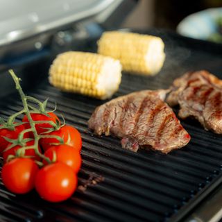 Tomatoes, sweetcorn and steak cooking on Ninja Woodfire Pro Connect XL