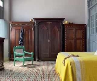 Dark closets with yellow covered bed in foreground