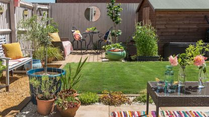 Compact garden with lawned centre, garden seating and plants in pots