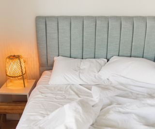 A duvet on a mattress on a blue bed frame.