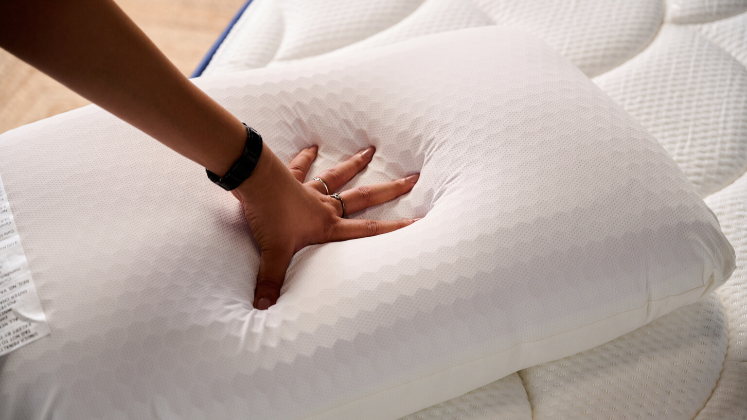 Hands pressing down on the Purple GridCloud pillow