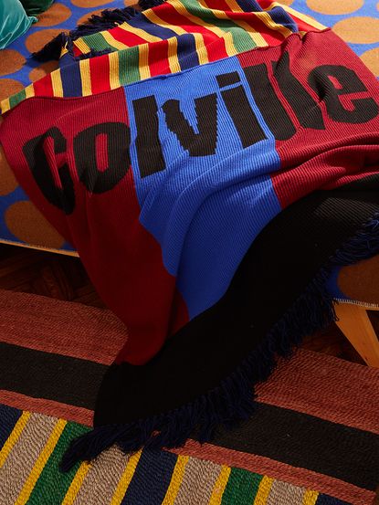 Coloured knitted throw, Colville worded across it