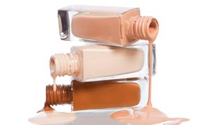 Foundation bottles on top of each other with liquid foundation pouring out